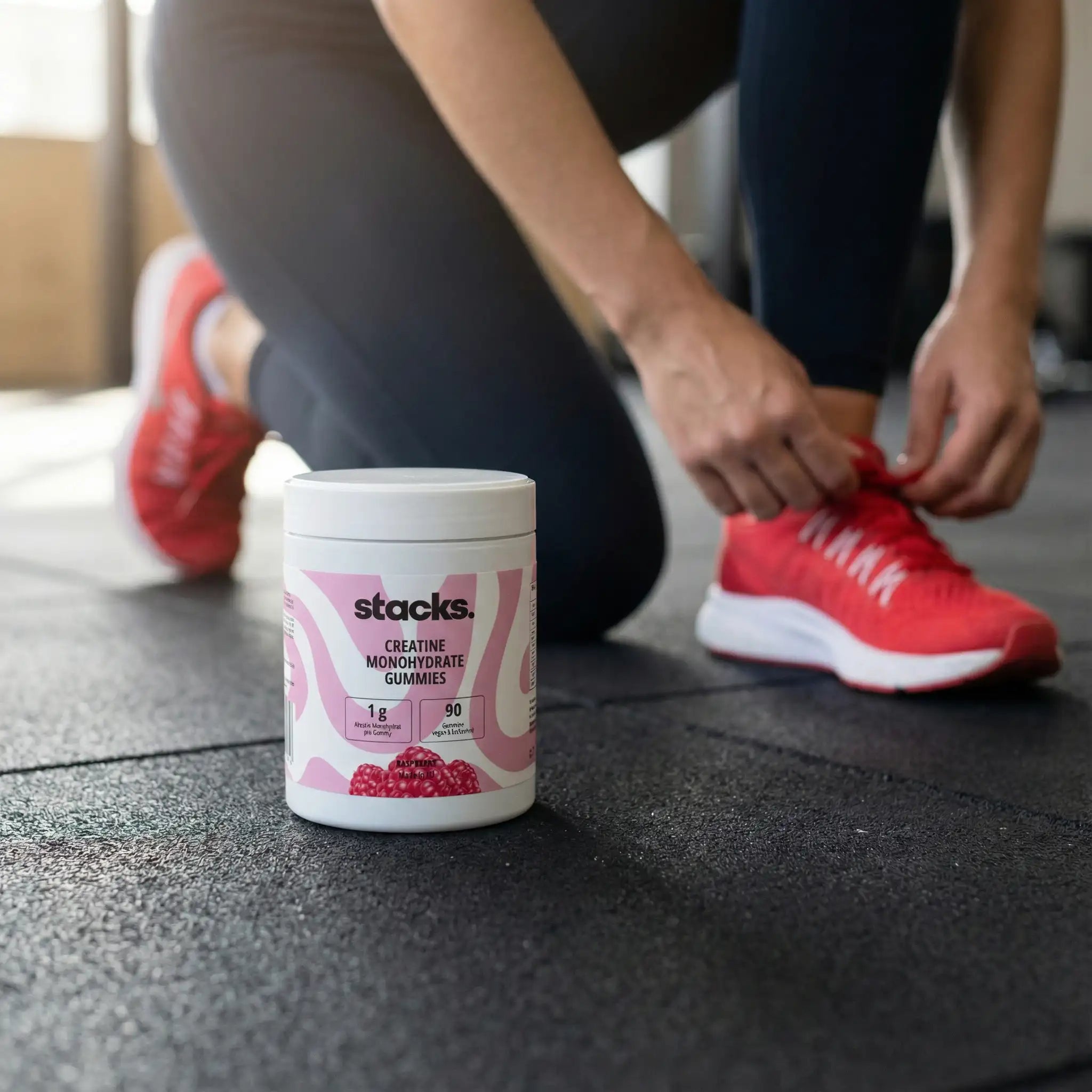Athletin bindet ihren Schuh, daneben steht eine Dose stacks Creatin Gummies.